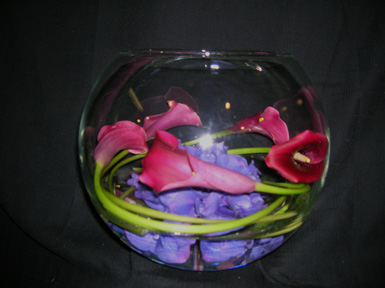 red cala lilies wrapped inside a glass bowl
